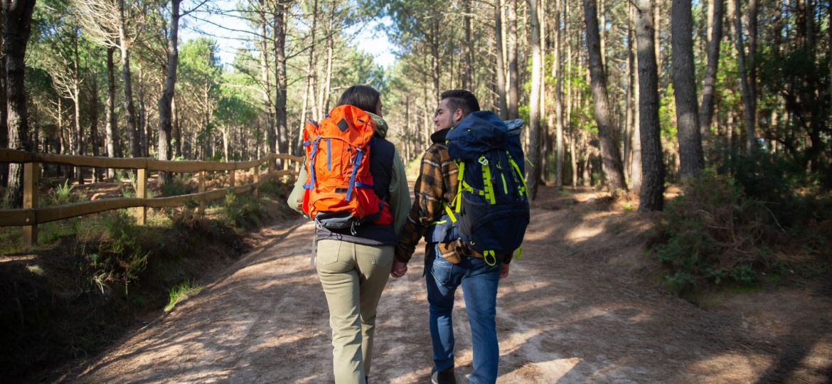 Back view of fond couple of young hikers