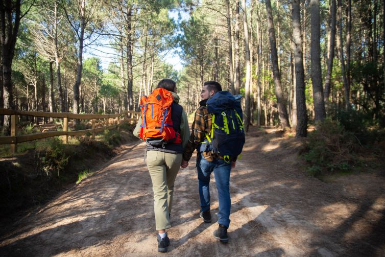 Back view of fond couple of young hikers